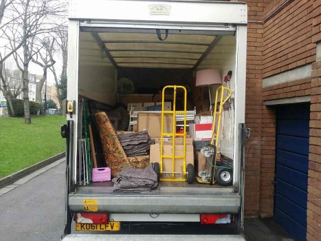 Charity volunteers collecting reusable furniture from skips